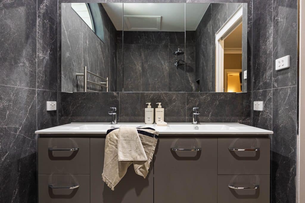bathroom renovation featuring grey tiling.